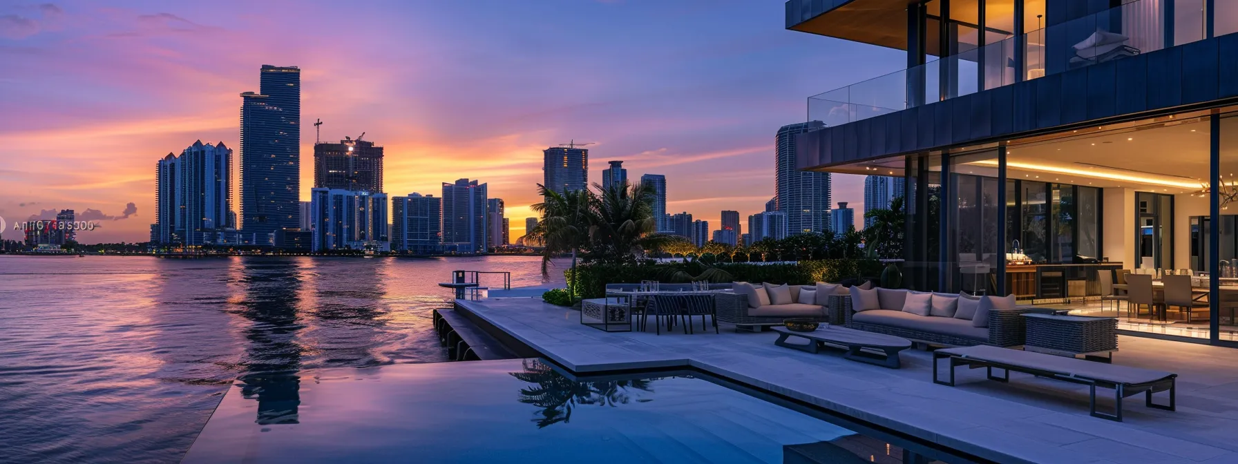 an opulent waterfront luxury home stands proud against the backdrop of miami's sleek high-rise skyline, gleaming in the vibrant hues of a sunset, with plush outdoor furniture overlooking the tranquil water.
